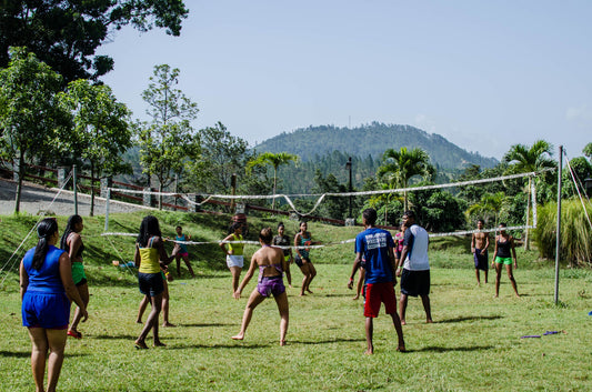 Friends playing a casual volleyball game on a grassy backyard court