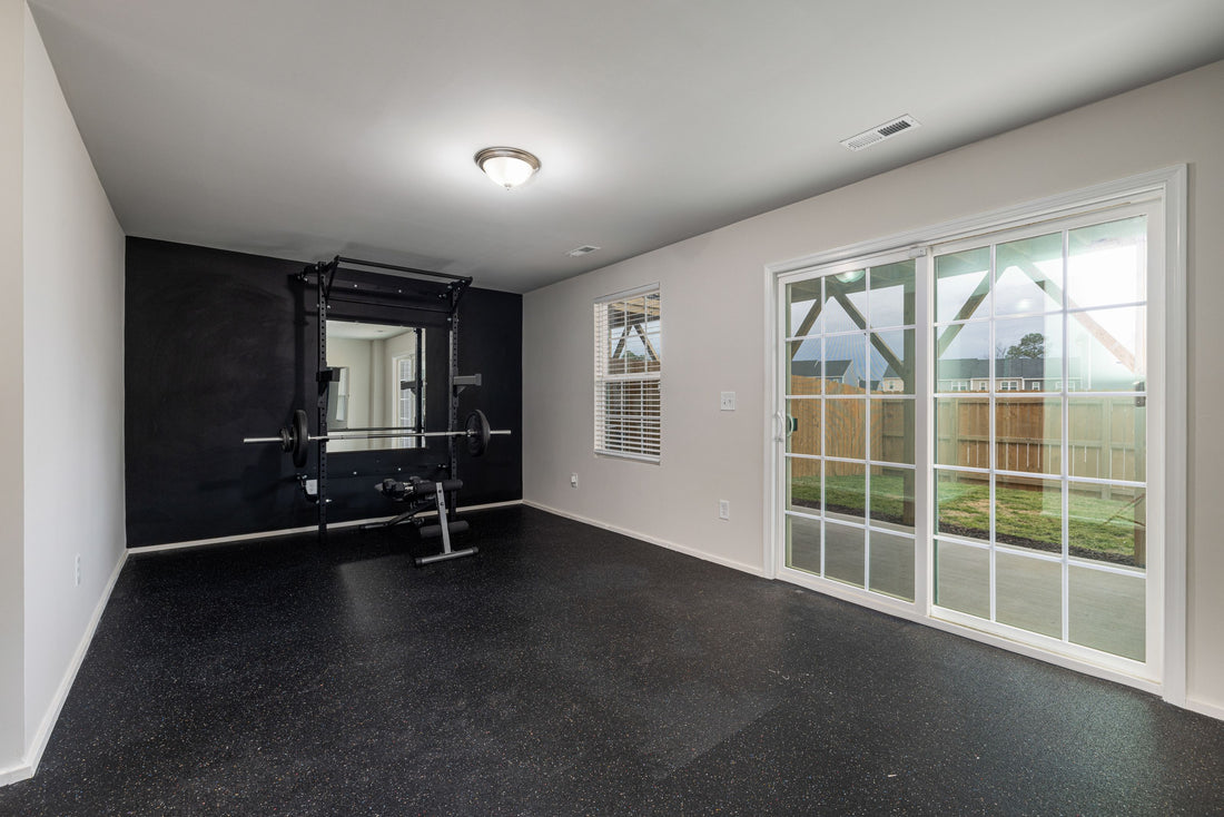 Small organized home gym with a squat rack and clear open floor space
