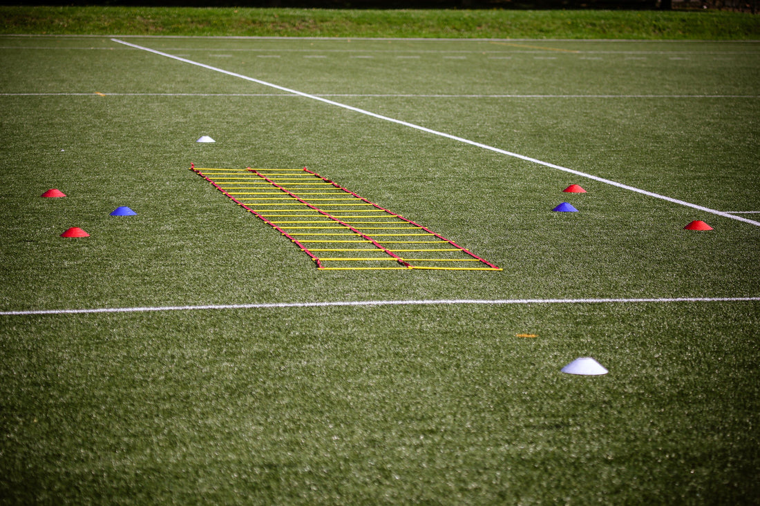 Agility ladder and marker cones set up on a turf field for speed drills