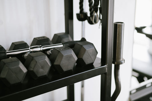 Dumbbells and cable attachments organized on a home gym storage rack