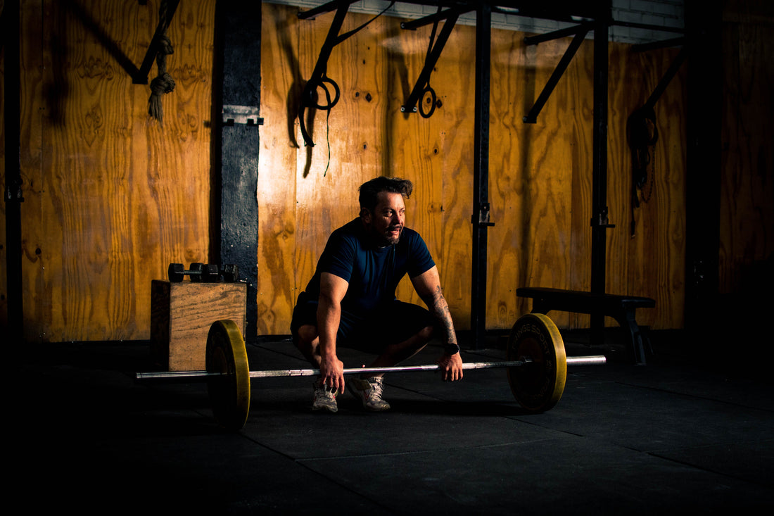 Man performing a barbell deadlift in a home garage gym