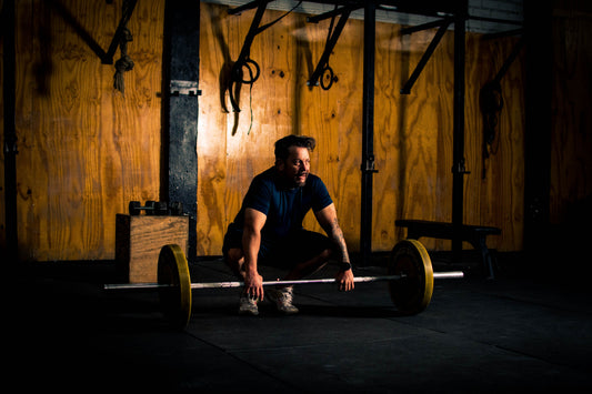 Man performing a barbell deadlift in a home garage gym