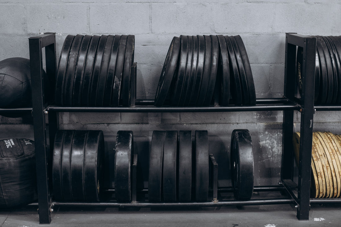Weight plates neatly organized on a storage rack against a wall