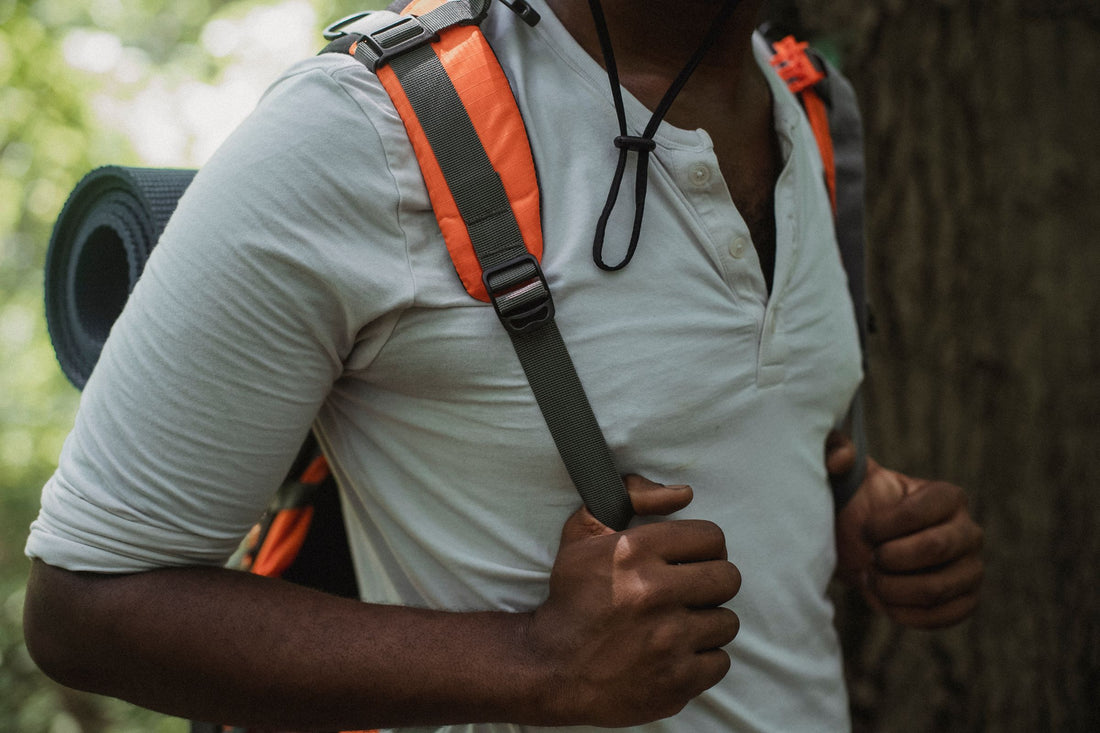 Adult walking outdoors with a loaded backpack for a rucking-style training walk