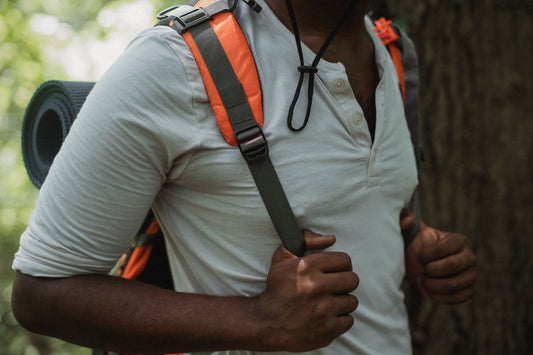 Adult walking outdoors with a loaded backpack for a rucking-style training walk