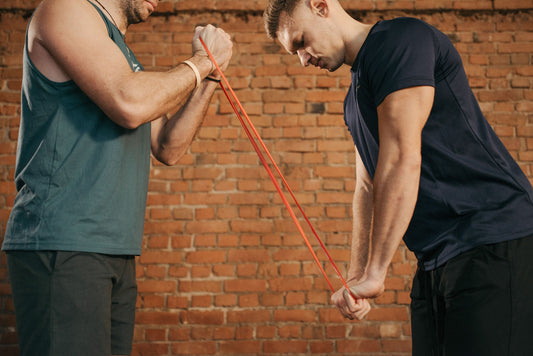 Two athletes training together with a resistance exercise band
