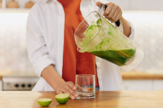 Plant-based protein shake being poured into a glass in a bright kitchen
