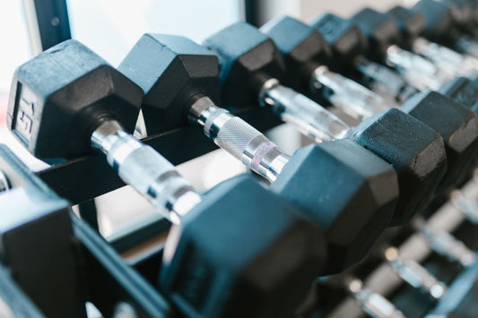 Rows of hex dumbbells organized on a standing storage rack